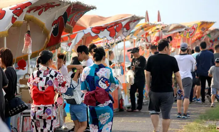 Stands et promeneurs en yukata au festival Shinwa Matsuri à Izumo au mois d’août